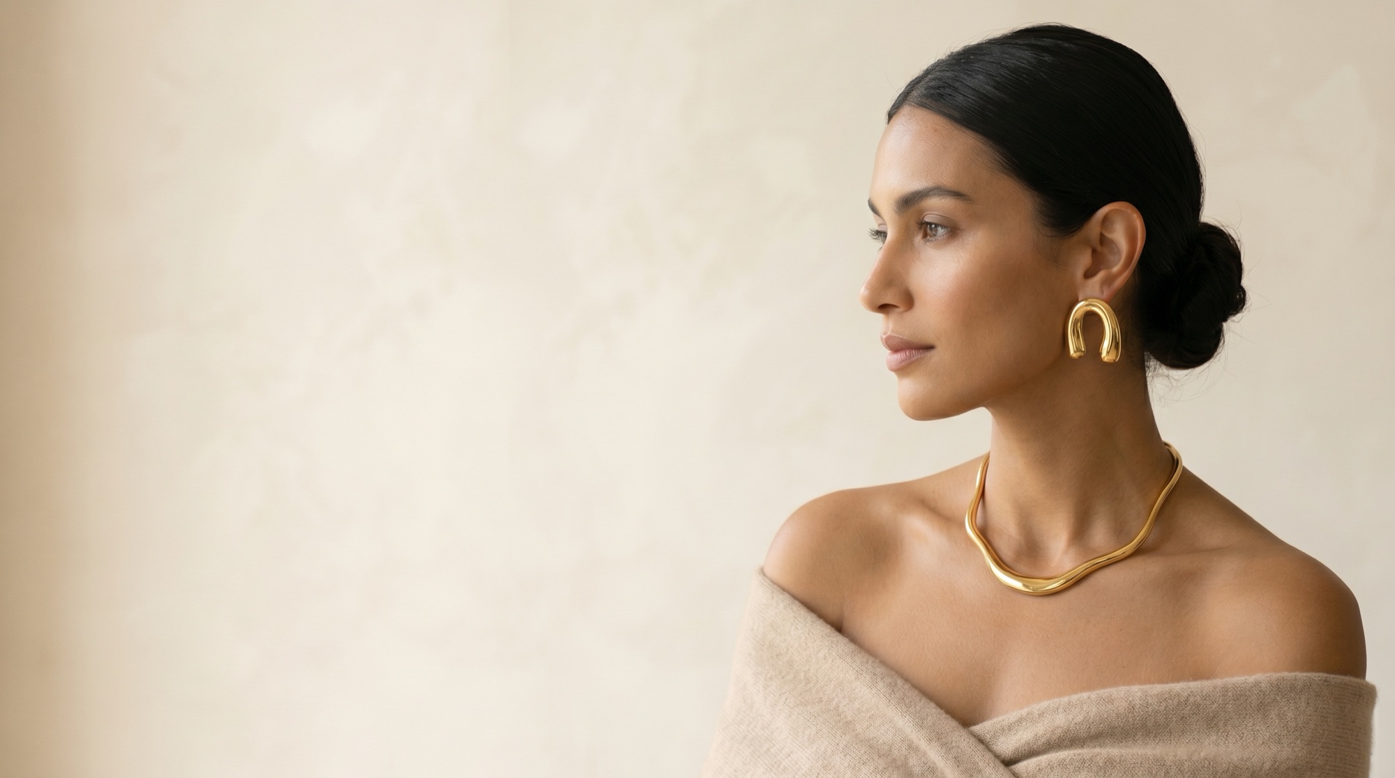 Mannequin portant des boucles d'oreilles arc en or et un collier or fluide ARCY